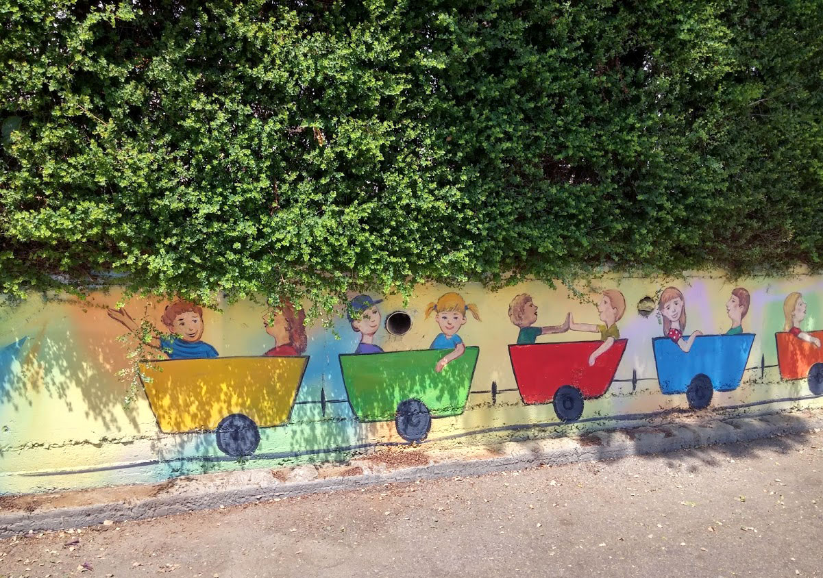 ציור של רכבת על הגדר של בית ספר