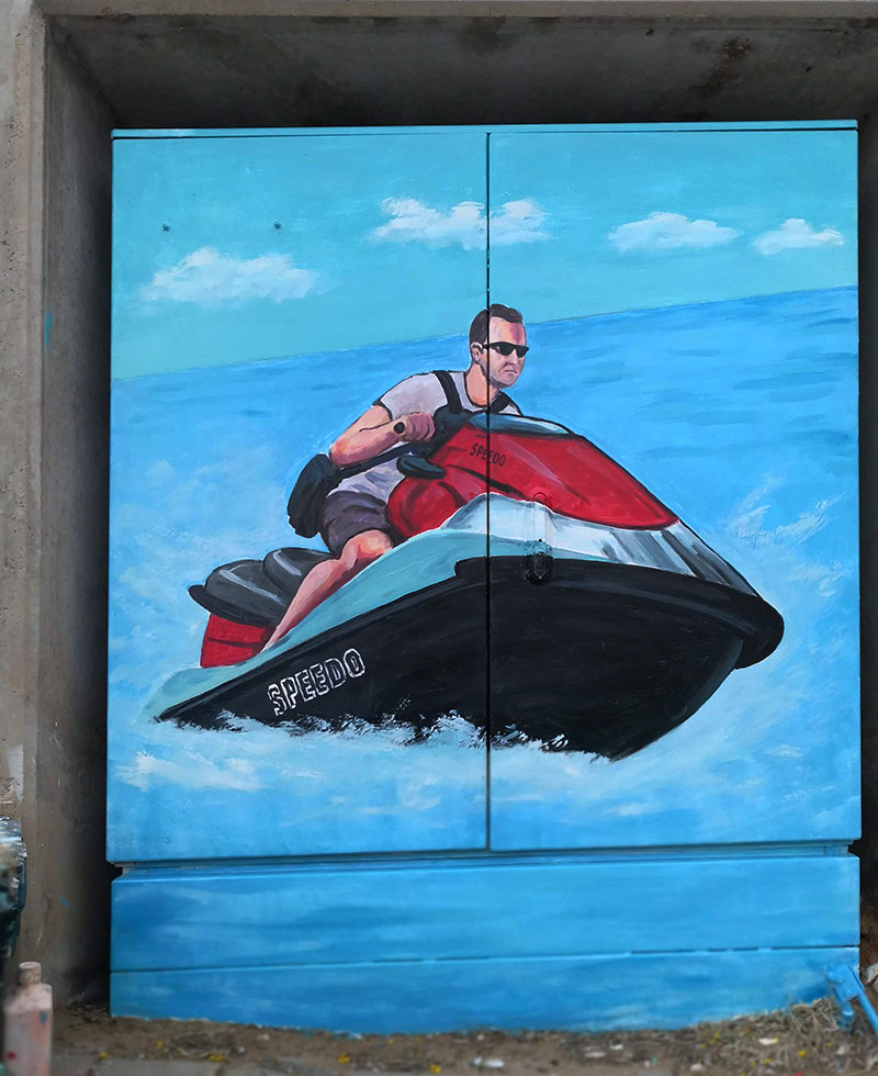 ציור על ארון חשמל של איש על סירת מנוע