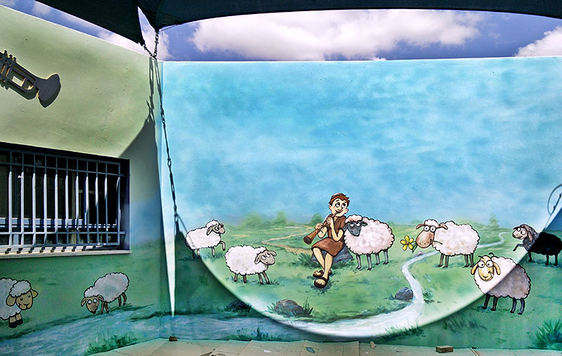 ציור קיר של ילד רועה מנגן